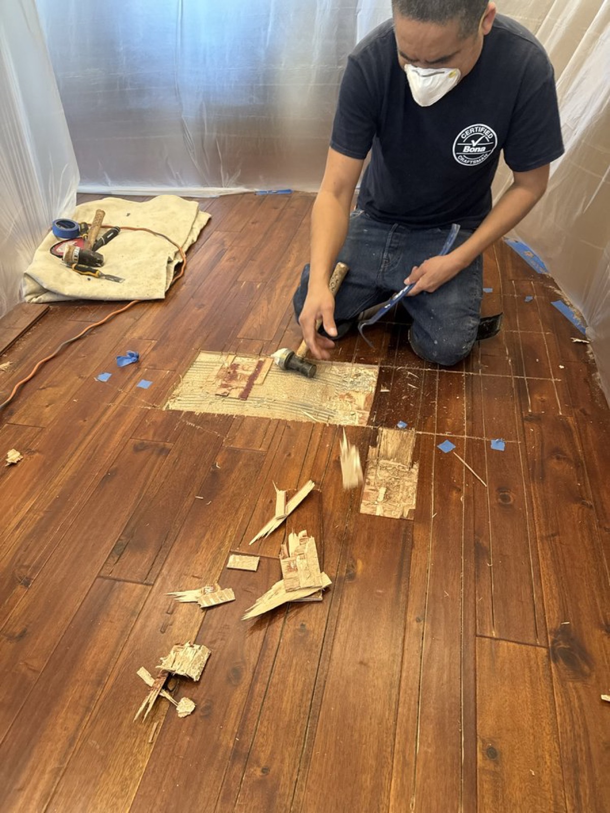 Atlantic craftsman in a Bona Certified Craftsman shirt removing damaged boards