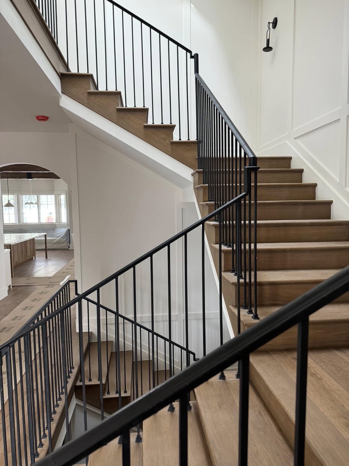 Full oak staircase with iron railings in a two-story entry